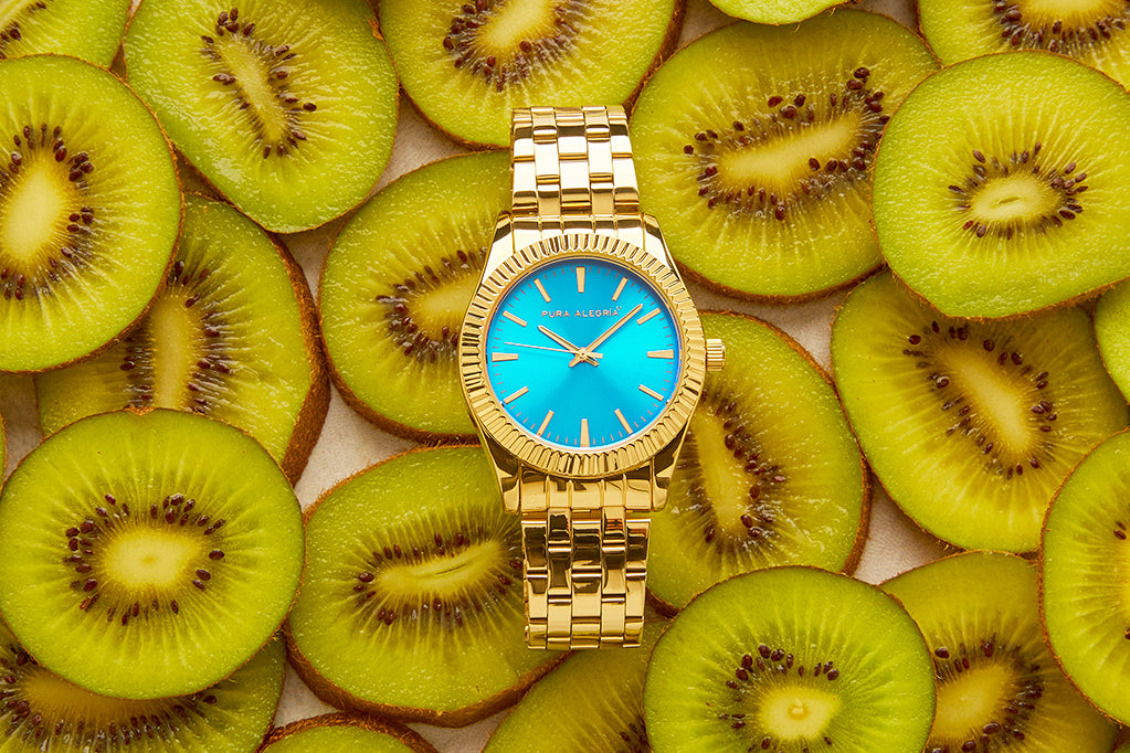 Reloj dorado para mujer con esfera de color turquesa.